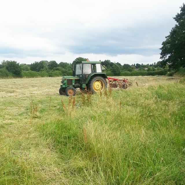 Tractor turning hay